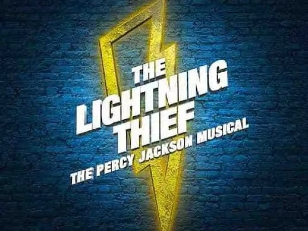 Text reads "The Lightning Thief: The Percy Jackson Musical" over a yellow lightning bolt on a blue brick wall.